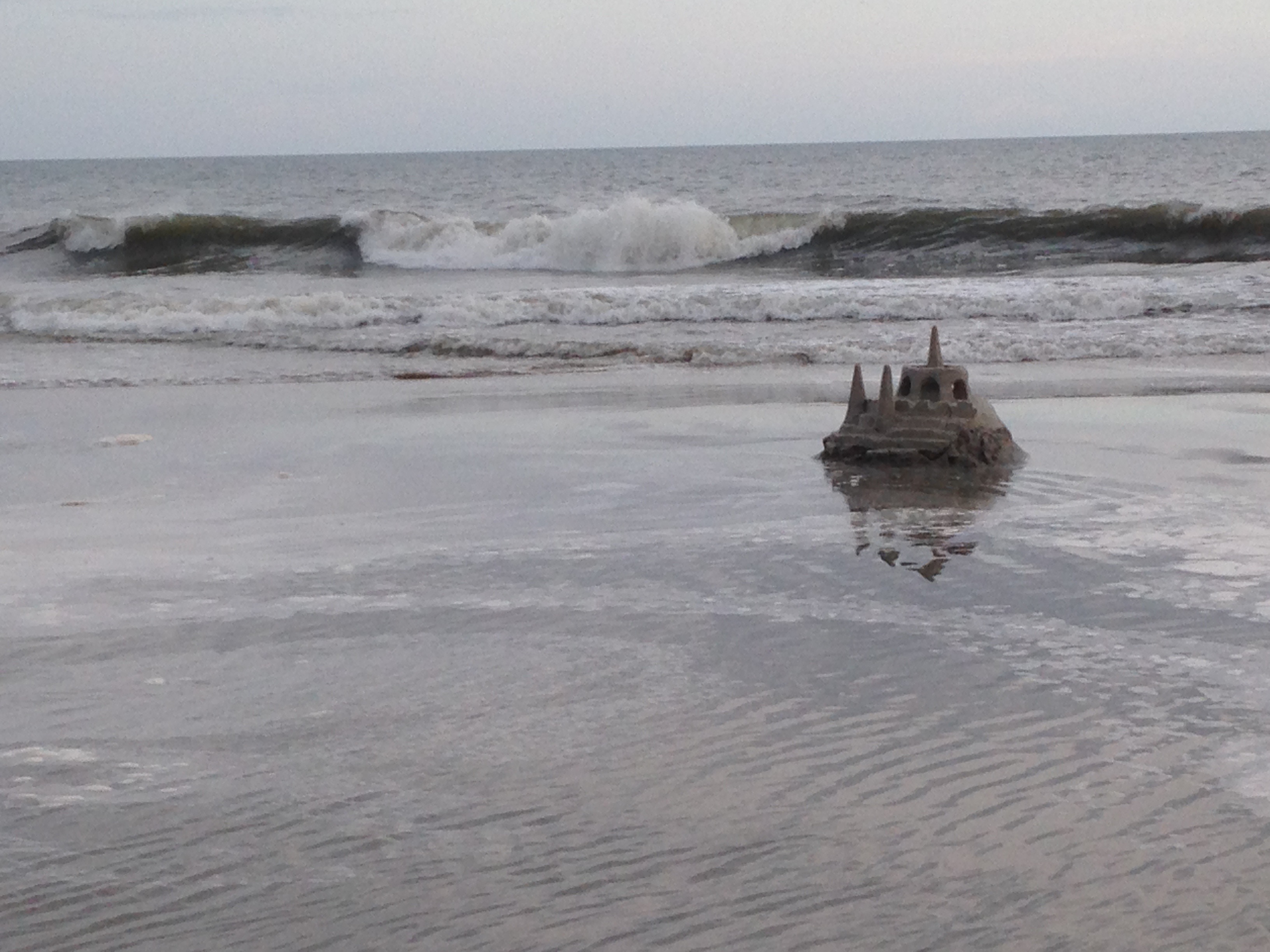Sandcastle being washed away